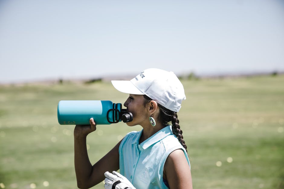 woman drinking from a water bottle